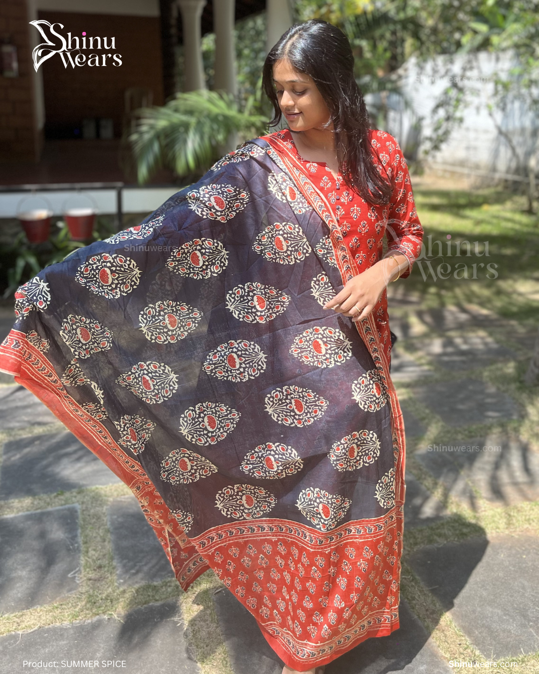 Woman holding a navy blue and red patterned scarf with 'Shinu Wears' branding.