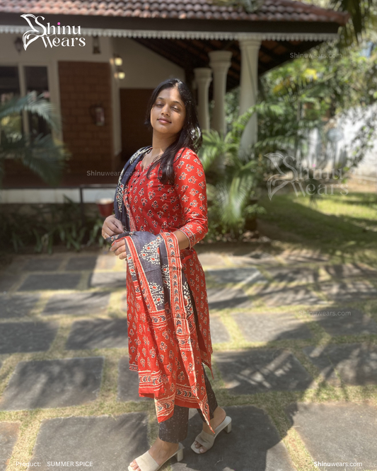 Woman in a red traditional outfit standing outdoors with 'Shinu Wears' branding.